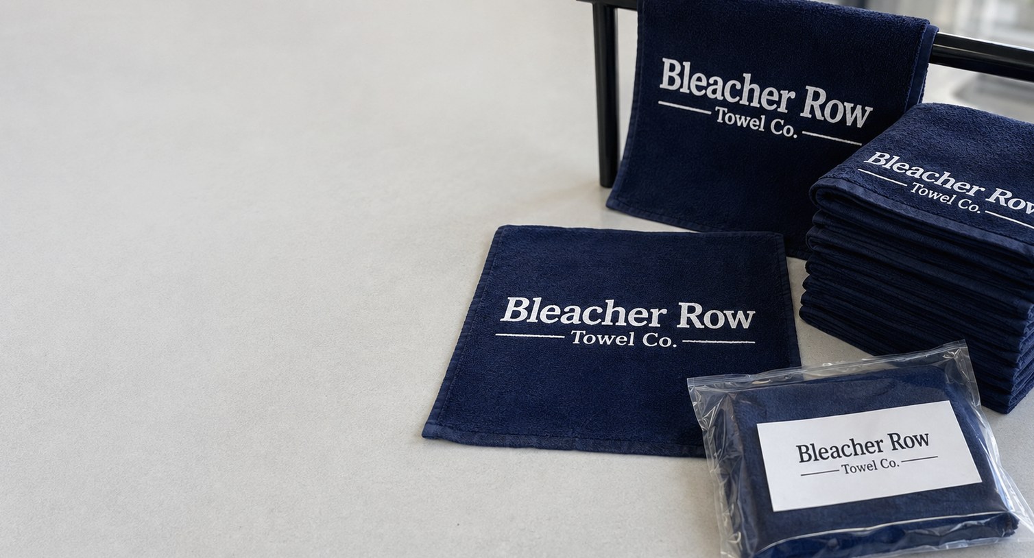 Custom printed rally towels laid flat, folded and bagged on a studio surface